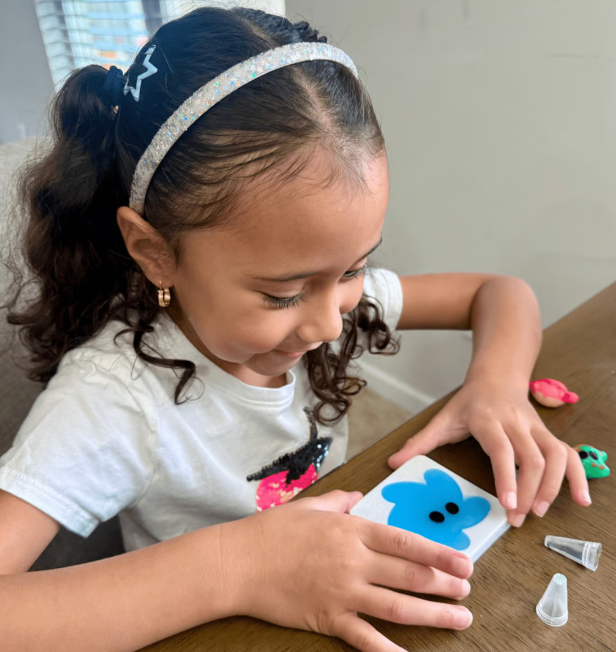 Child playing with colorful squishy water elf figures instead of a tablet
